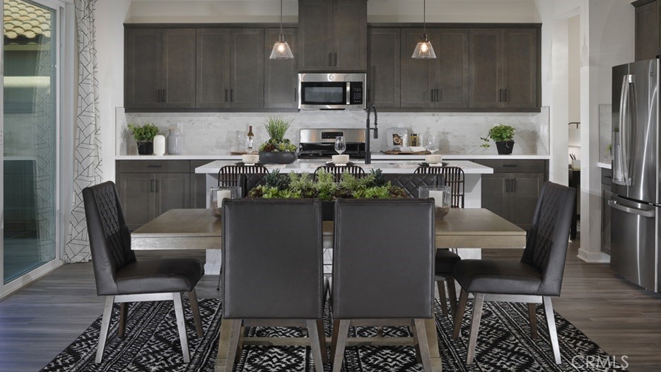 36970 Corvina Way Beaumont, CA 92223 - Photo 4 of 12 a kitchen with a dining table chairs and a refrigerator