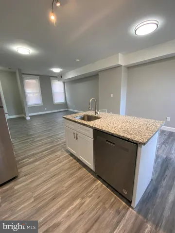 a kitchen with sink cabinets and wooden floor