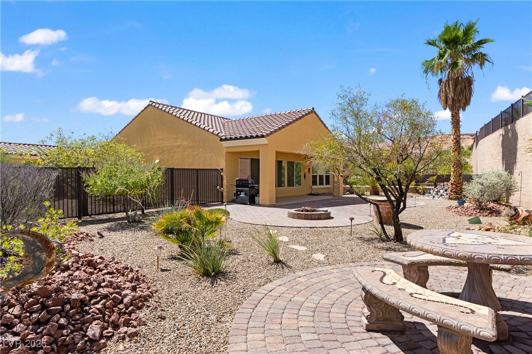 1551 Watchmans Point Mesquite, NV 89034 - Photo 1 of 62 Rear view of property featuring a patio area, a fenced backyard, an outdoor fire pit, stucco siding, and a tiled roof