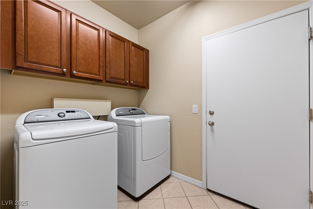 1551 Watchmans Point Mesquite, NV 89034 - Photo 14 of 62 Washroom featuring washer and clothes dryer, light tile patterned flooring, and cabinet space