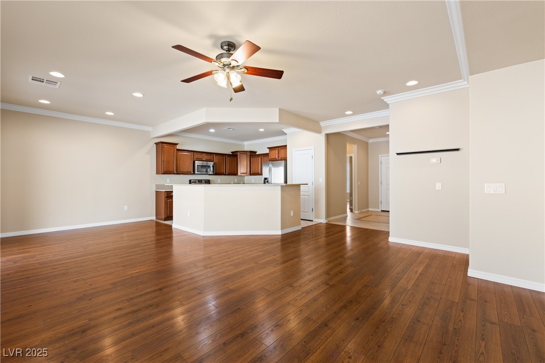 1551 Watchmans Point Mesquite, NV 89034 - Photo 19 of 62 Unfurnished living room with dark wood-type flooring, a ceiling fan, recessed lighting, and crown molding