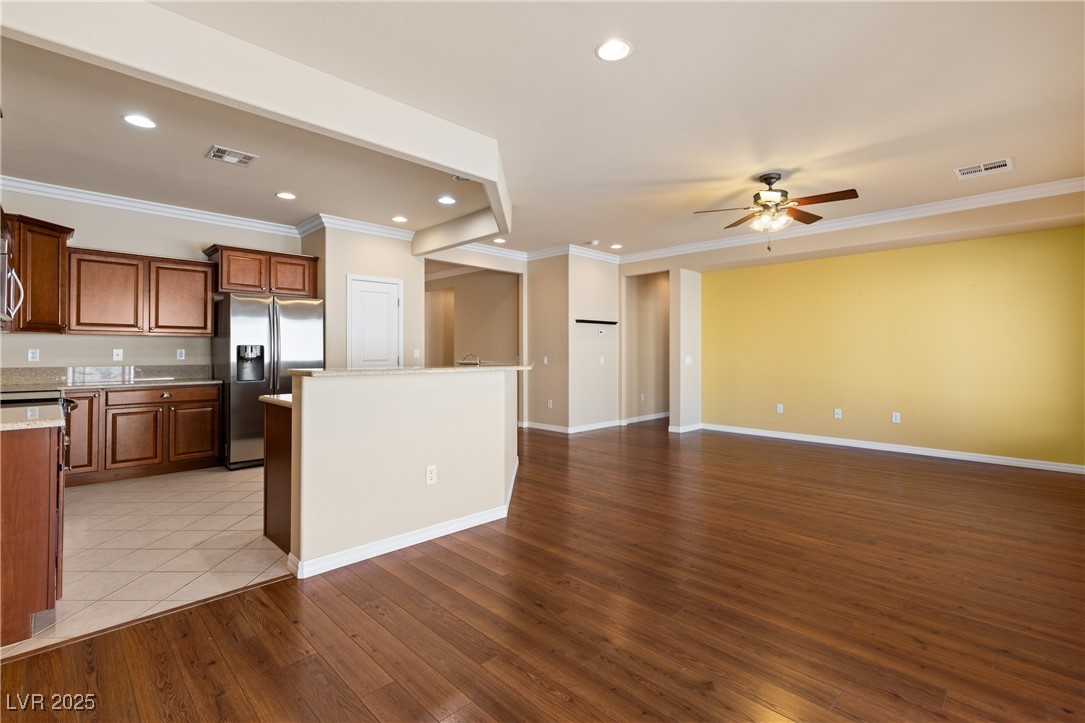 1551 Watchmans Point Mesquite, NV 89034 - Photo 23 of 62 Kitchen with ornamental molding, stainless steel refrigerator with ice dispenser, light wood-style flooring, recessed lighting, and brown cabinets