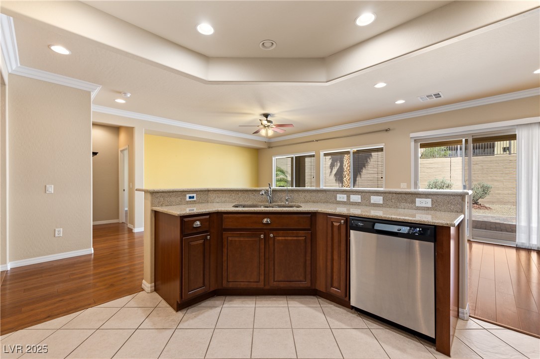 1551 Watchmans Point Mesquite, NV 89034 - Photo 25 of 62 Kitchen with a raised ceiling, a center island with sink, dishwasher, recessed lighting, and light tile patterned flooring