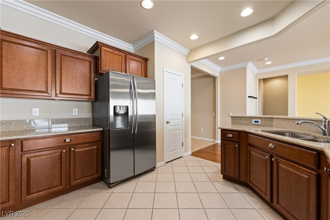1551 Watchmans Point Mesquite, NV 89034 - Photo 26 of 62 Kitchen featuring crown molding, stainless steel fridge with ice dispenser, light stone countertops, light tile patterned floors, and recessed lighting