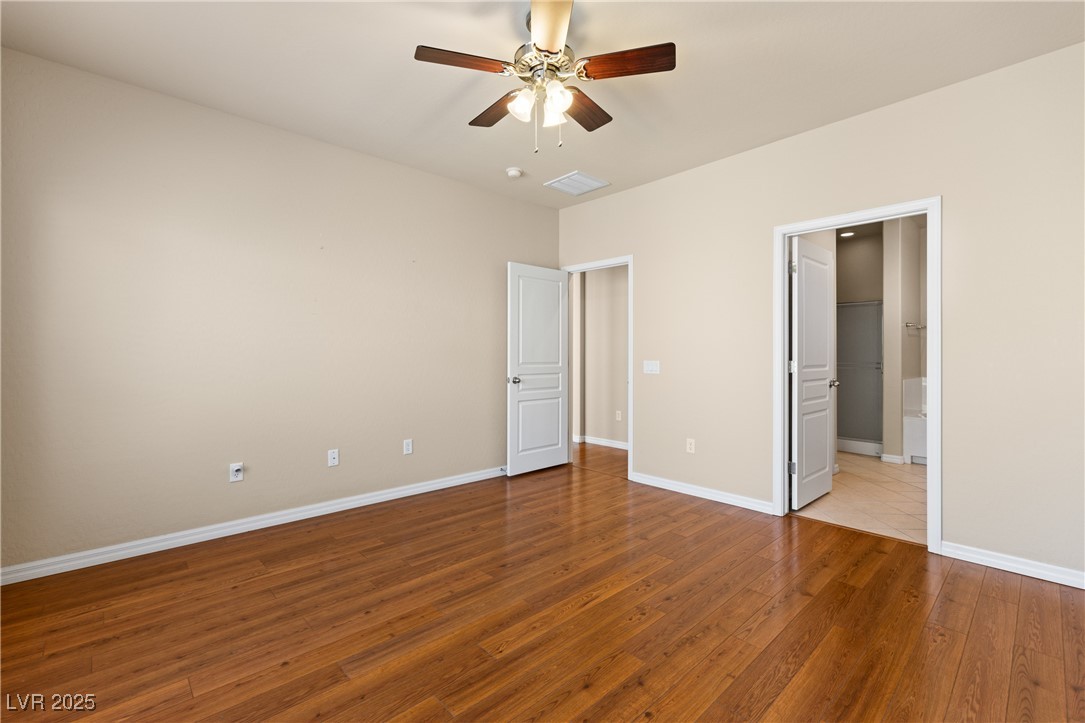 1551 Watchmans Point Mesquite, NV 89034 - Photo 30 of 62 Unfurnished bedroom featuring light wood-style floors, ceiling fan, and connected bathroom