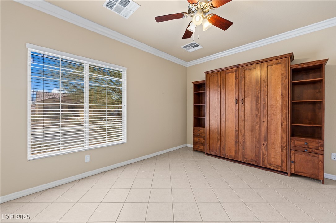 1551 Watchmans Point Mesquite, NV 89034 - Photo 36 of 62 Unfurnished bedroom featuring crown molding, a ceiling fan, and light tile patterned flooring