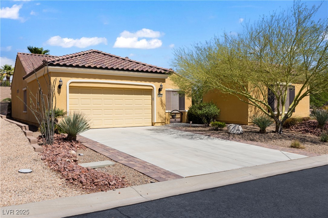 1551 Watchmans Point Mesquite, NV 89034 - Photo 39 of 62 View of front of home with stucco siding, driveway, a garage, and a tiled roof