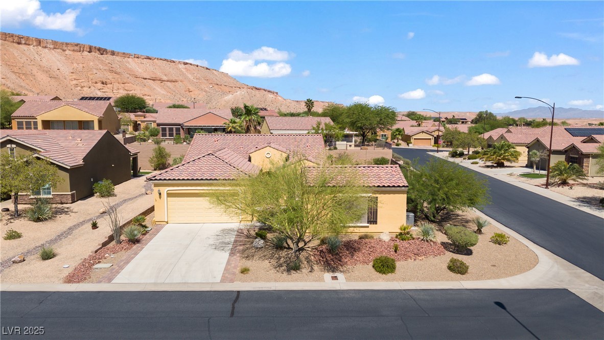 1551 Watchmans Point Mesquite, NV 89034 - Photo 51 of 62 View of front of house featuring a residential view, stucco siding, driveway, and a mountain view