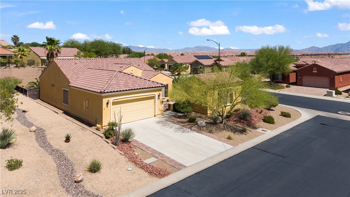 1551 Watchmans Point Mesquite, NV 89034 - Photo 52 of 62 Mediterranean / spanish-style house featuring stucco siding, a residential view, driveway, a mountain view, and a garage