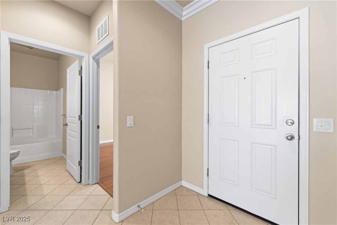 1551 Watchmans Point Mesquite, NV 89034 - Photo 8 of 62 Foyer featuring light tile patterned flooring and crown molding