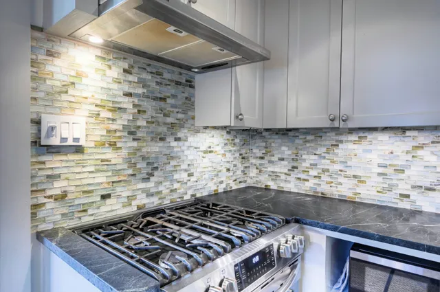a kitchen with granite countertop stainless steel appliances a refrigerator and cabinets