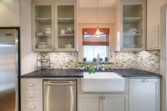 a kitchen with kitchen island granite countertop a refrigerator and a sink