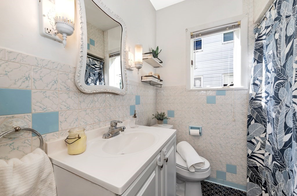 34 Harvard Street, Unit 1 Arlington, MA 02476 - Photo 14 of 36 a bathroom with a sink a toilet and a mirror