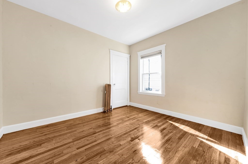 34 Harvard Street, Unit 1 Arlington, MA 02476 - Photo 15 of 36 a view of an empty room with wooden floor and a window