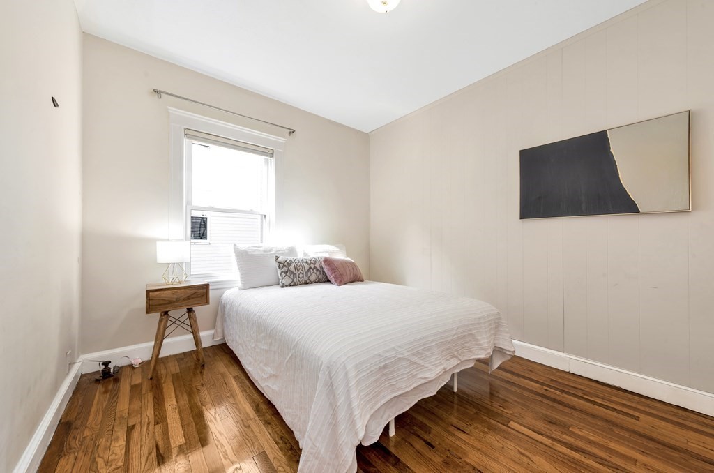 34 Harvard Street, Unit 1 Arlington, MA 02476 - Photo 17 of 36 a bedroom with a bed and flat screen tv