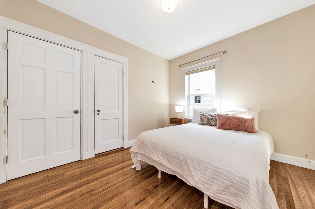 34 Harvard Street, Unit 1 Arlington, MA 02476 - Photo 18 of 36 a bedroom with a bed and wooden floor