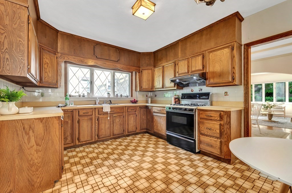 34 Harvard Street, Unit 1 Arlington, MA 02476 - Photo 20 of 36 a kitchen with a stove a sink a microwave a dining table and chairs