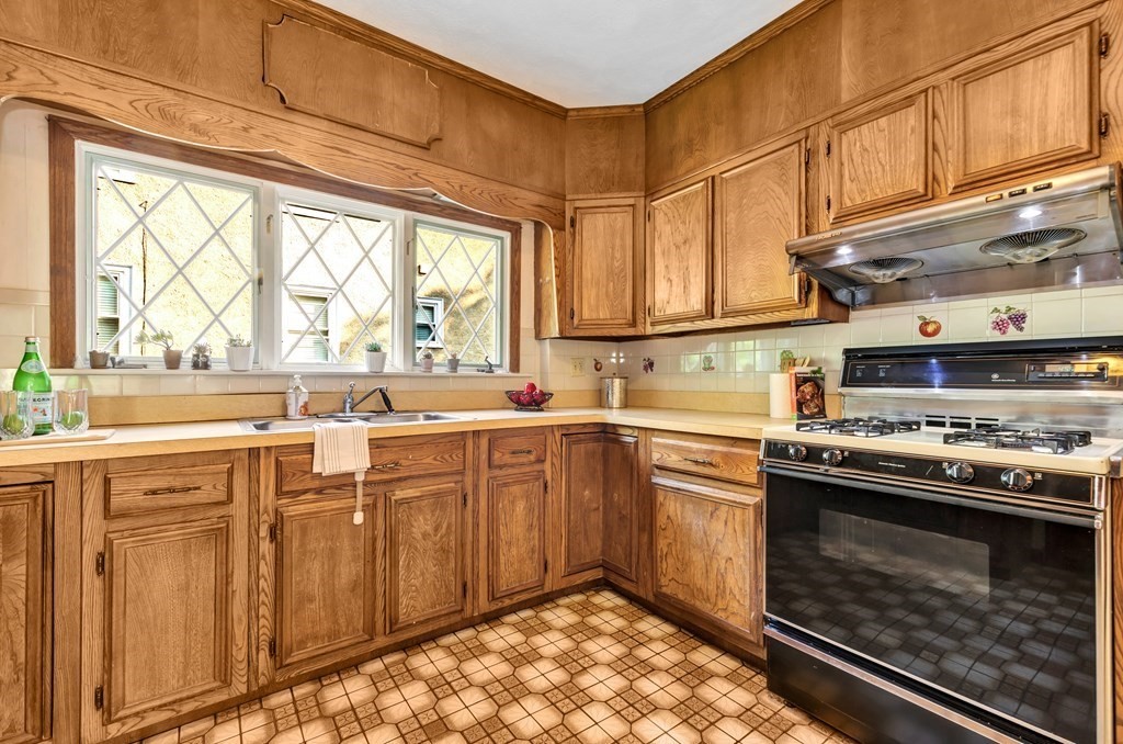 34 Harvard Street, Unit 1 Arlington, MA 02476 - Photo 21 of 36 a kitchen with stainless steel appliances granite countertop a stove a sink and a microwave