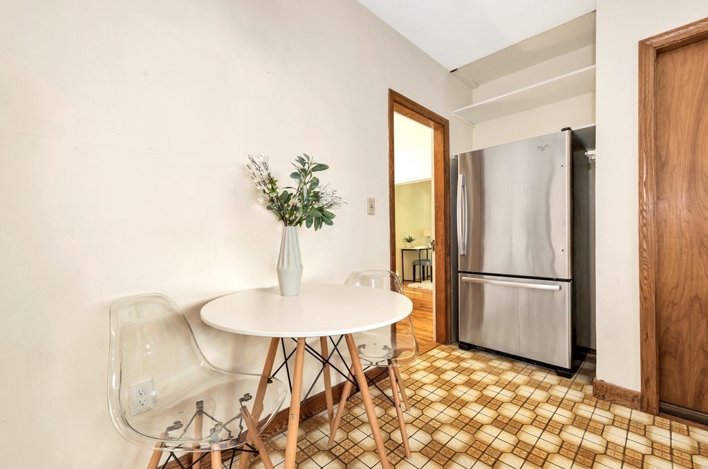 34 Harvard Street, Unit 1 Arlington, MA 02476 - Photo 24 of 36 a kitchen with stainless steel appliances a refrigerator and a table