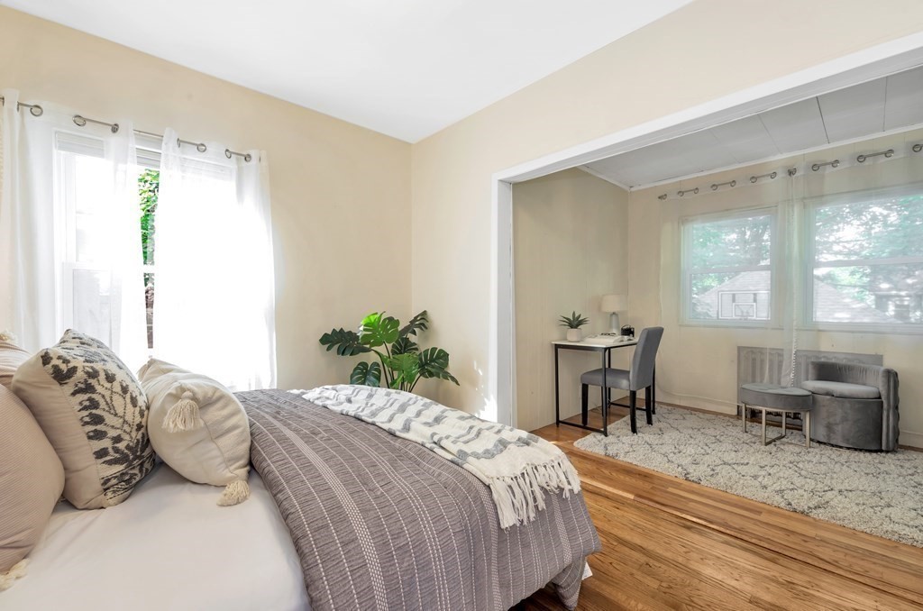 34 Harvard Street, Unit 1 Arlington, MA 02476 - Photo 27 of 36 a bedroom with a bed table chair and a window
