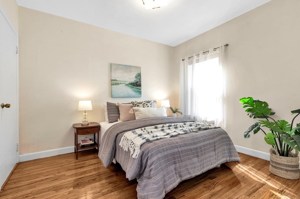 34 Harvard Street, Unit 1 Arlington, MA 02476 - Photo 28 of 36 a bedroom with a bed and a potted plant