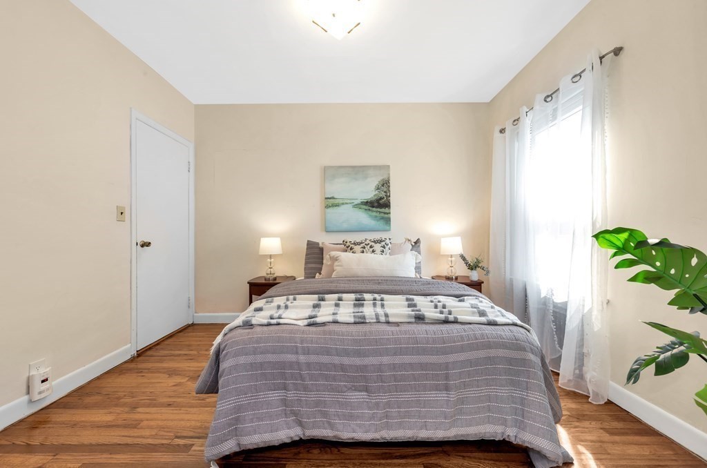 34 Harvard Street, Unit 1 Arlington, MA 02476 - Photo 29 of 36 a bedroom with a bed and wooden floor