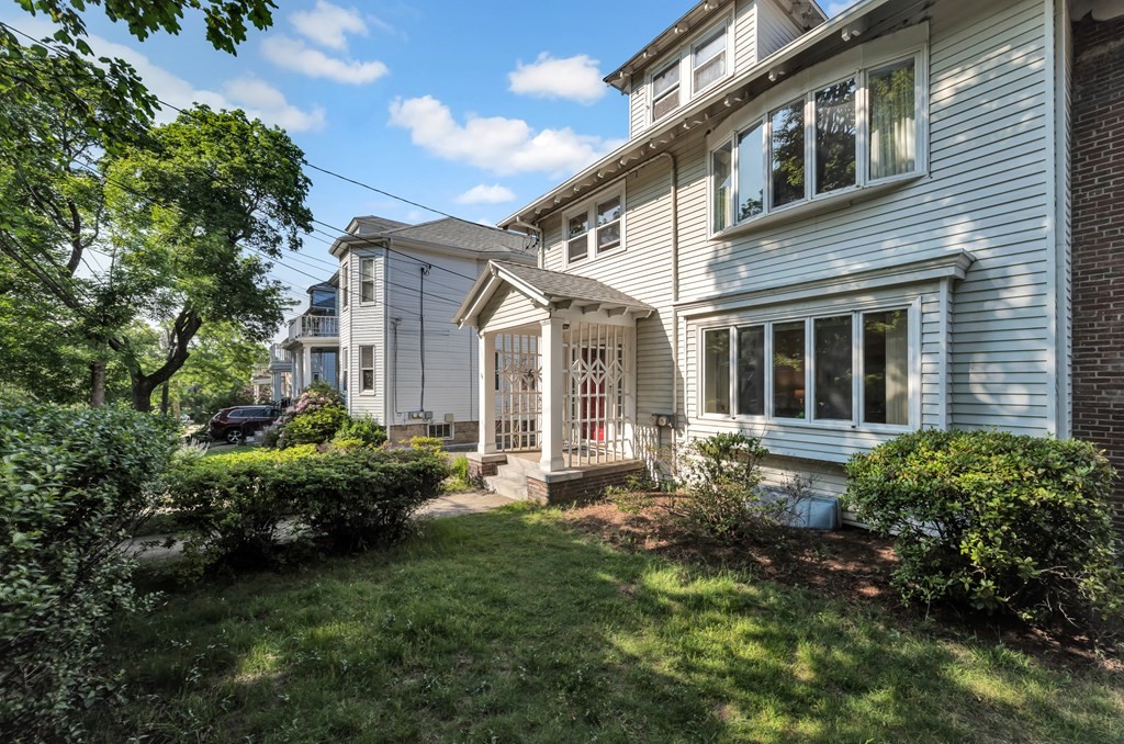 34 Harvard Street, Unit 1 Arlington, MA 02476 - Photo 3 of 36 a front view of a house with a garden and plants