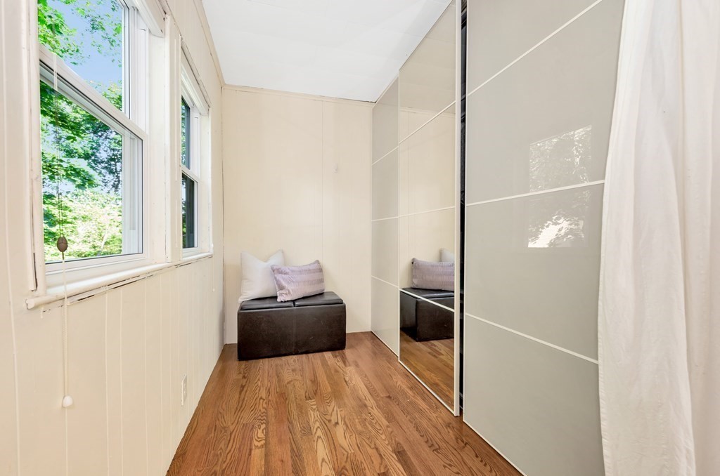 34 Harvard Street, Unit 1 Arlington, MA 02476 - Photo 34 of 36 a hallway with a large window and wooden floor