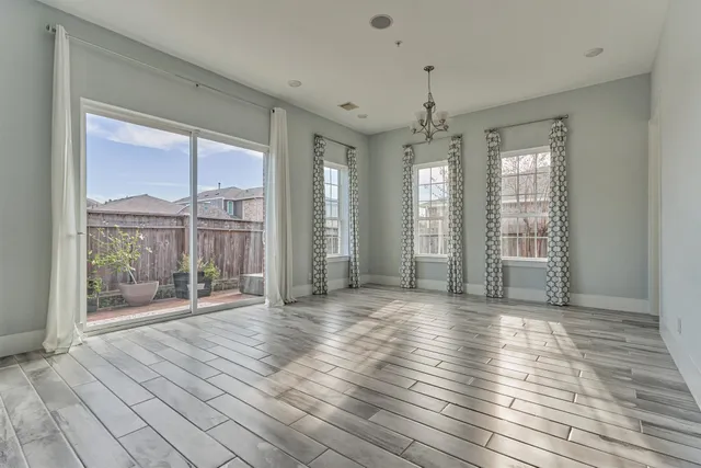 a view of an empty room with glass door and balcony