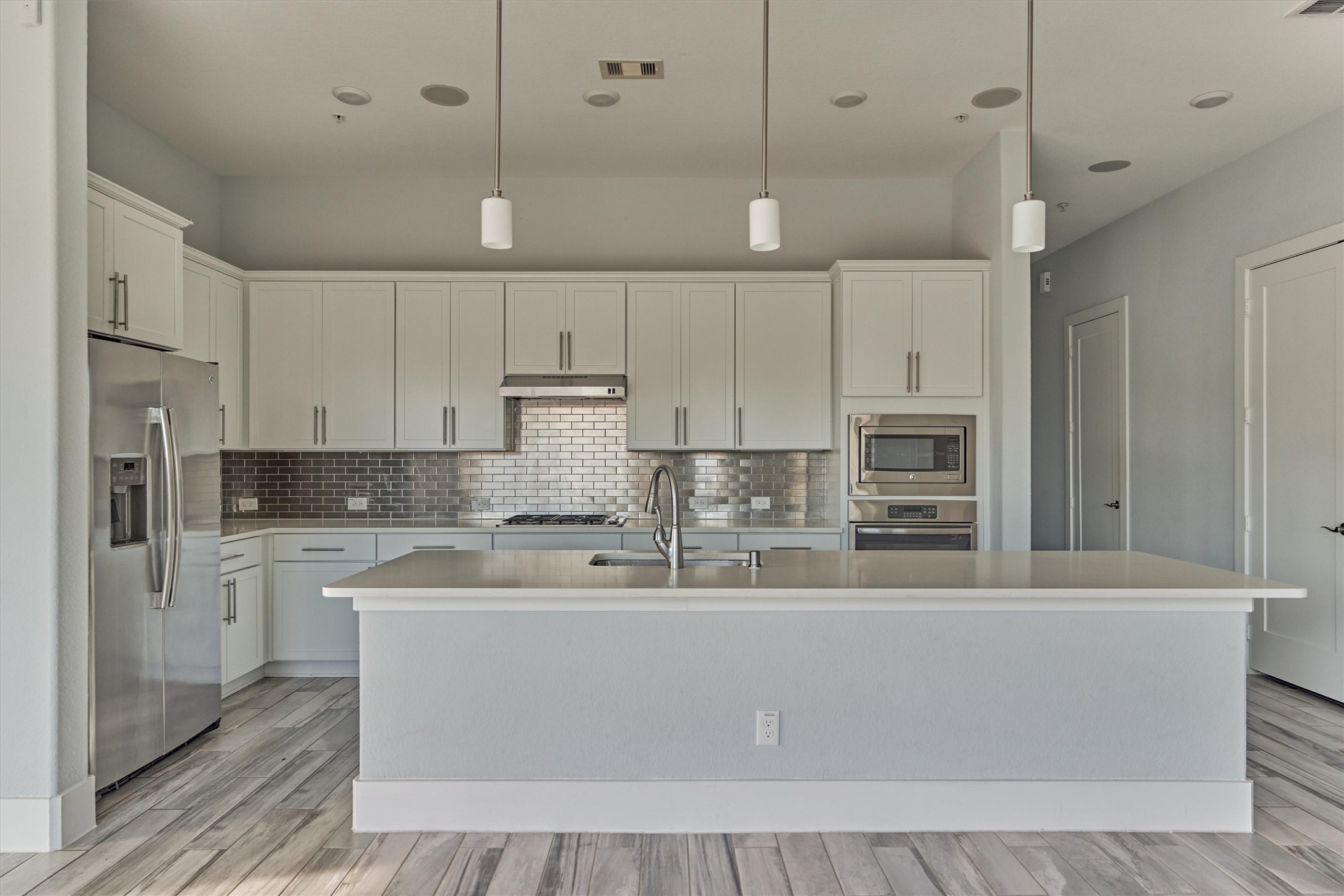 2113 Solstice Boulevard Spring, TX 77386 - Photo 20 of 48 a large kitchen with stainless steel appliances kitchen island a large counter top and white cabinets