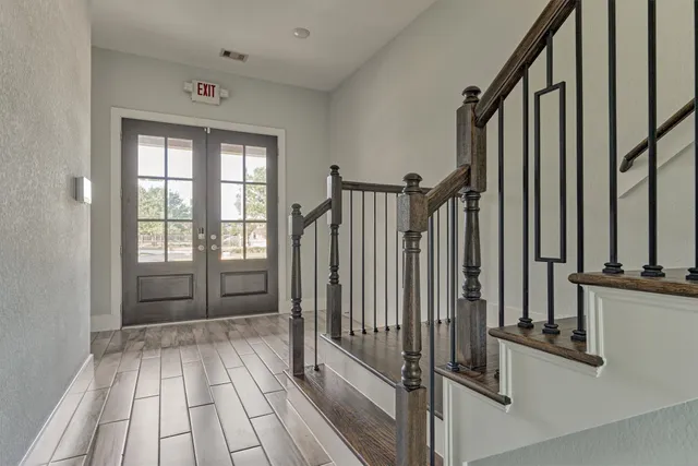 a view of a hallway with wooden floor and staircase
