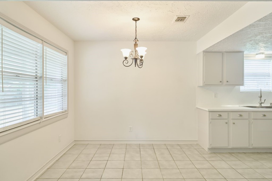 619 Pinewood Drive Conroe, TX 77385 - Photo 17 of 44 a view of a kitchen with a white cabinet and a window