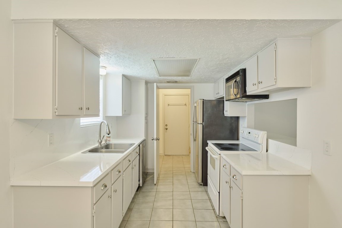 619 Pinewood Drive Conroe, TX 77385 - Photo 19 of 44 a kitchen with stainless steel appliances a sink stove and cabinets
