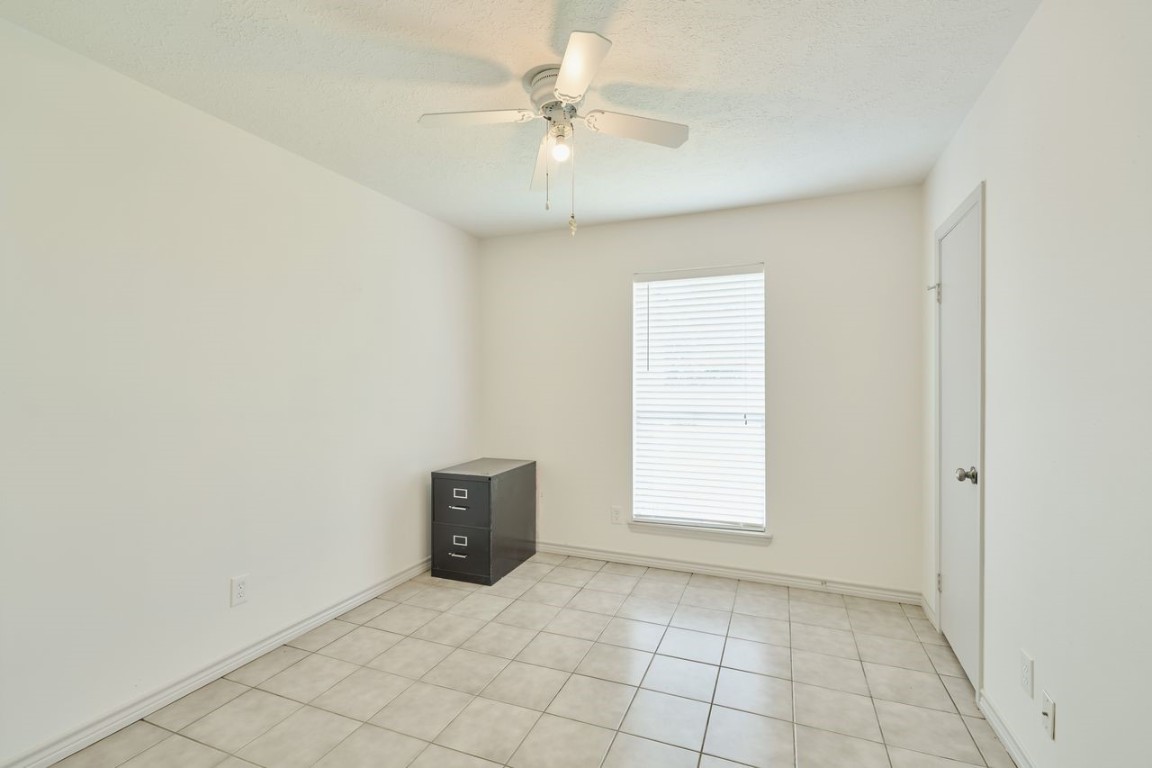 619 Pinewood Drive Conroe, TX 77385 - Photo 24 of 44 an empty room with windows and ceiling fan