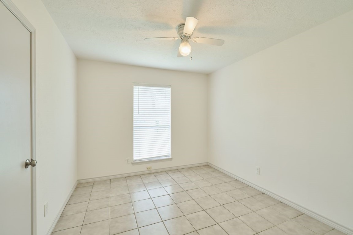 619 Pinewood Drive Conroe, TX 77385 - Photo 28 of 44 an empty room with a ceiling fan and window