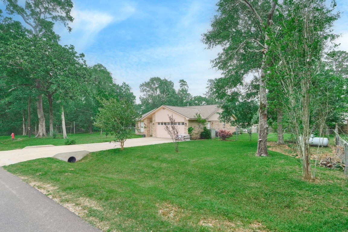 619 Pinewood Drive Conroe, TX 77385 - Photo 3 of 44 a backyard of a house with plants and tree