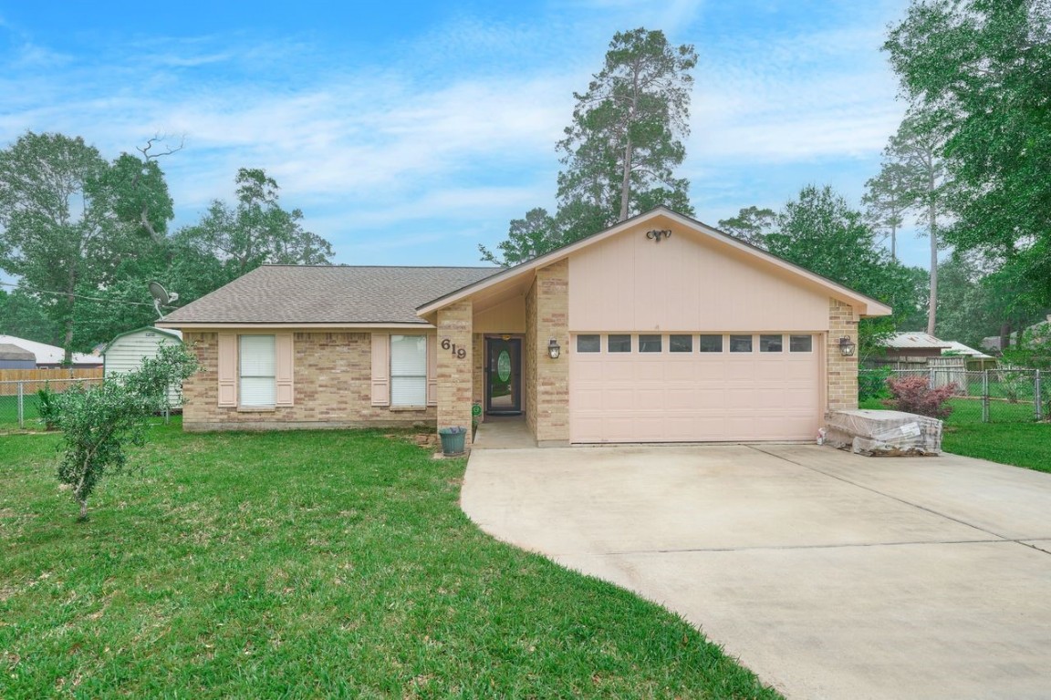 619 Pinewood Drive Conroe, TX 77385 - Photo 4 of 44 a view of a house with a yard and garage