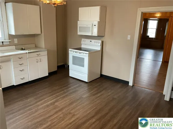 a kitchen with cabinets wooden floor and stainless steel appliances