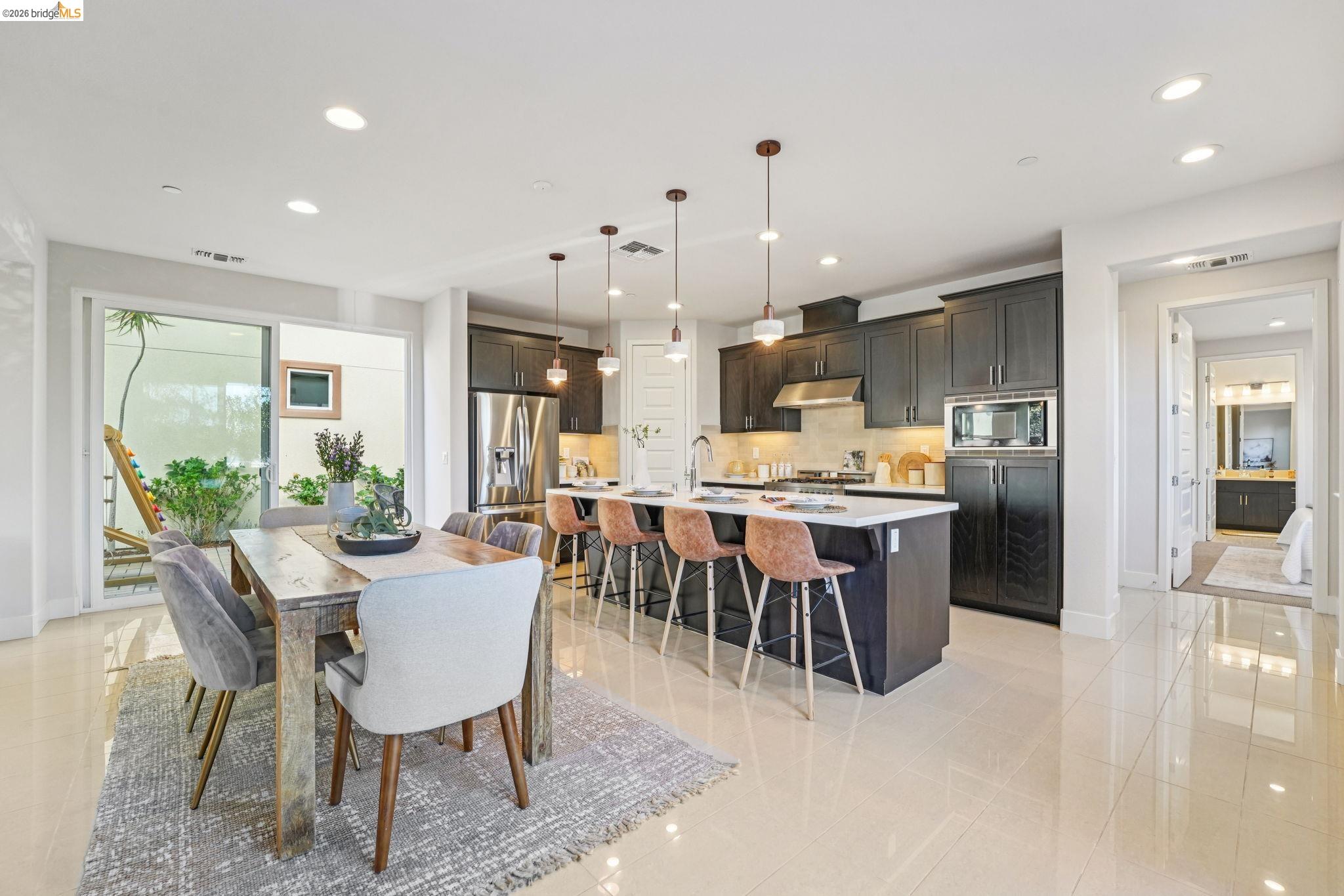 2770 Bette Street Alameda, CA 94501 - Photo 16 of 60 a dining area with stainless steel appliances kitchen island granite countertop a dining table chairs and a refrigerator
