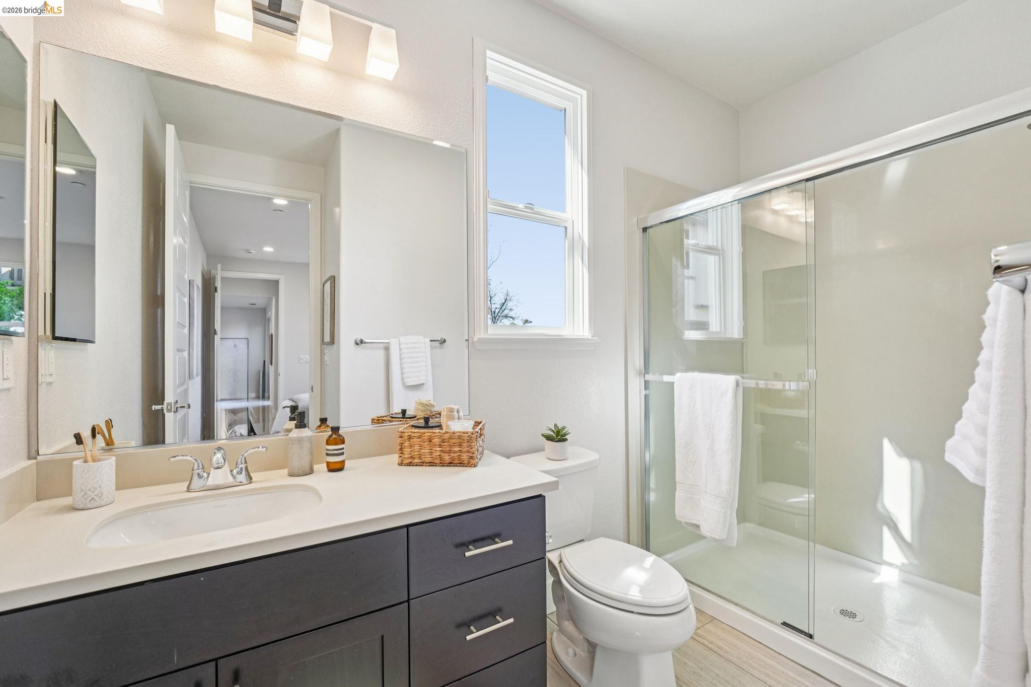 2770 Bette Street Alameda, CA 94501 - Photo 22 of 60 a bathroom with a double vanity sink toilet mirror and shower