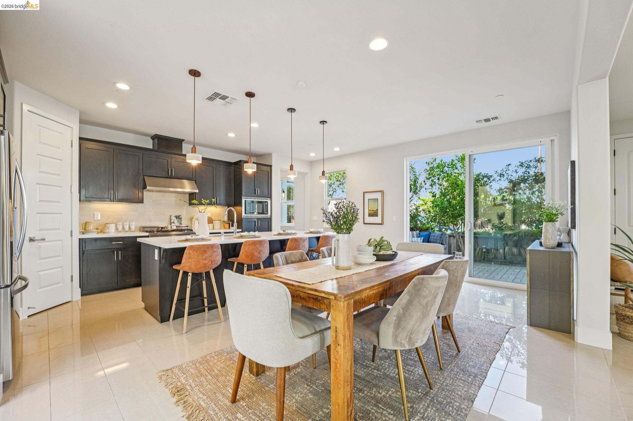 2770 Bette Street Alameda, CA 94501 - Photo 9 of 60 a dining room with stainless steel appliances kitchen island granite countertop a table chairs and a view of living room