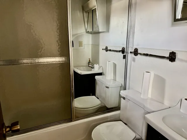 a white toilet sitting next to a bathroom sink