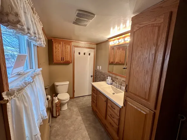 a bathroom with a sink a toilet a mirror and shower