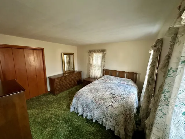 a bed sitting in a bedroom next to a window