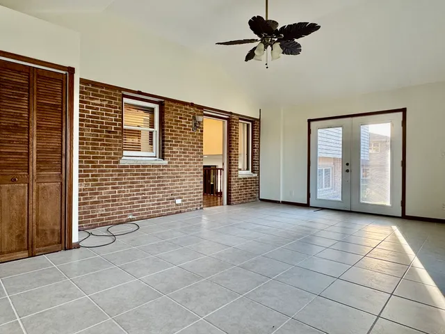 a view of a livingroom with a chandelier fan and windows