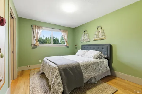 a bedroom with a bed and a window with painted walls