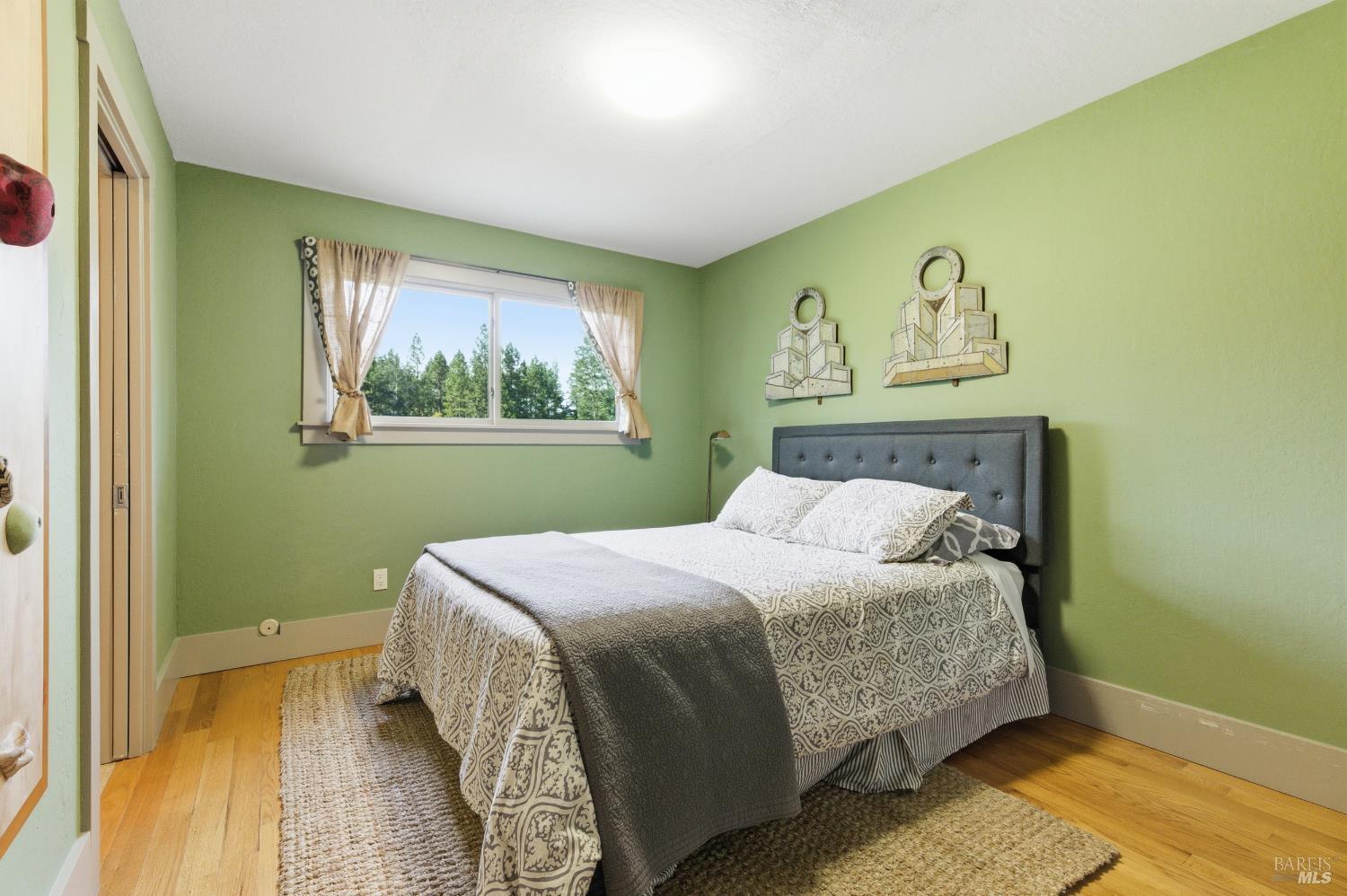 425 Cold Springs Road Angwin, CA 94508 - Photo 19 of 53 a bedroom with a bed and wooden floor