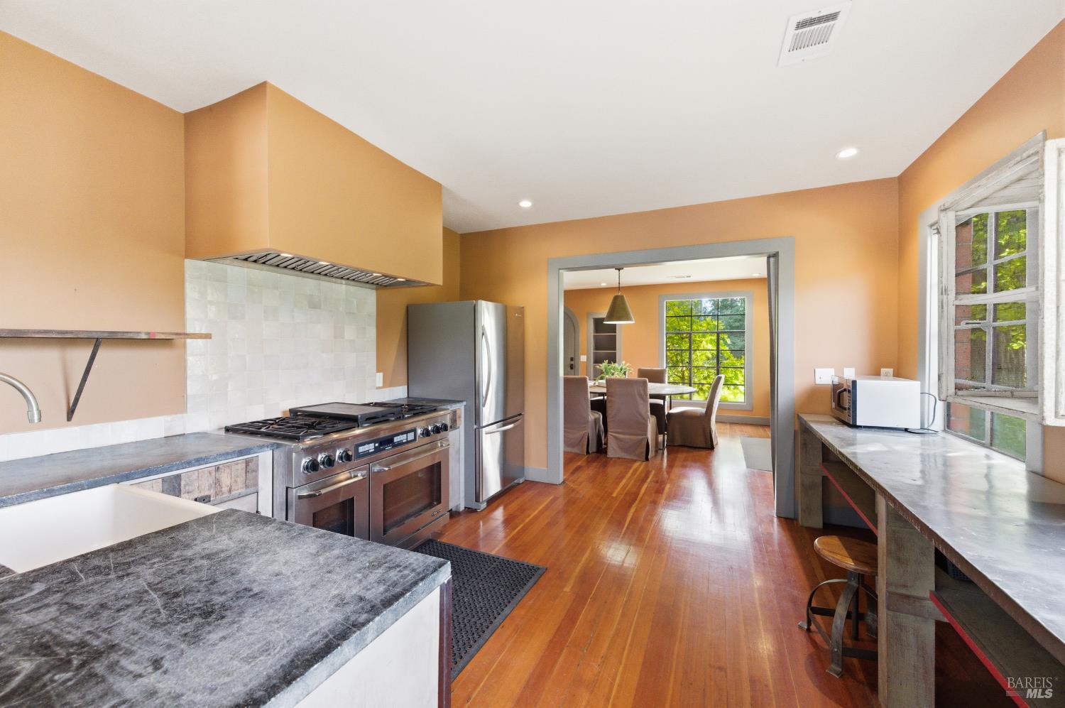 425 Cold Springs Road Angwin, CA 94508 - Photo 39 of 53 a kitchen with stainless steel appliances granite countertop a stove top oven a sink dishwasher and a dining table with garden view