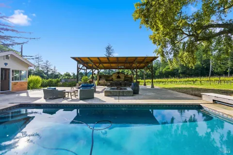 a view of a patio with a table chairs and a small yard