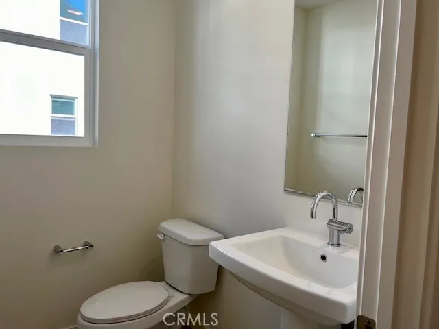 a kitchen with stainless steel appliances a sink a stove a refrigerator cabinets and living room view